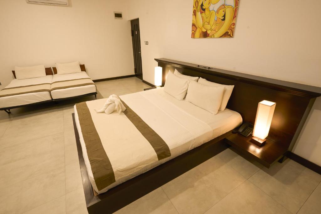 Postel nebo postele na pokoji v ubytování Rajarata Hotel Anuradhapura