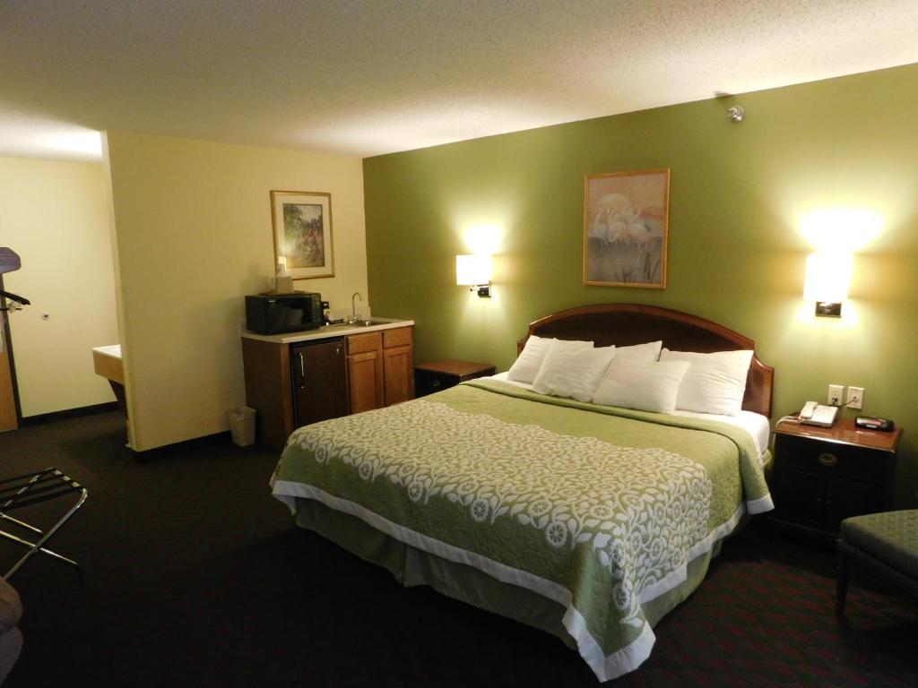 a hotel room with a large bed with green walls at Days Inn by Wyndham Lexington NE in Lexington