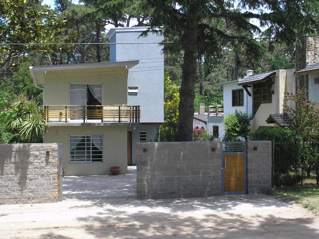 una casa blanca con una valla en frente a Cedro Del Pinar en Villa Gesell