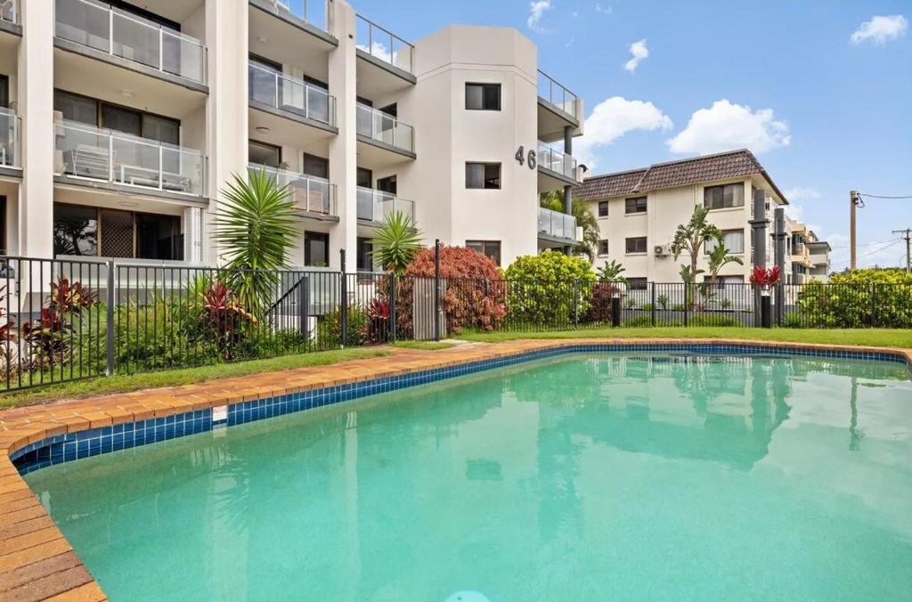 a swimming pool in front of a apartment building at Beach Front Bliss - Luxurious 3 Bedroom Beachfront Apartment in Maroochydore in Maroochydore