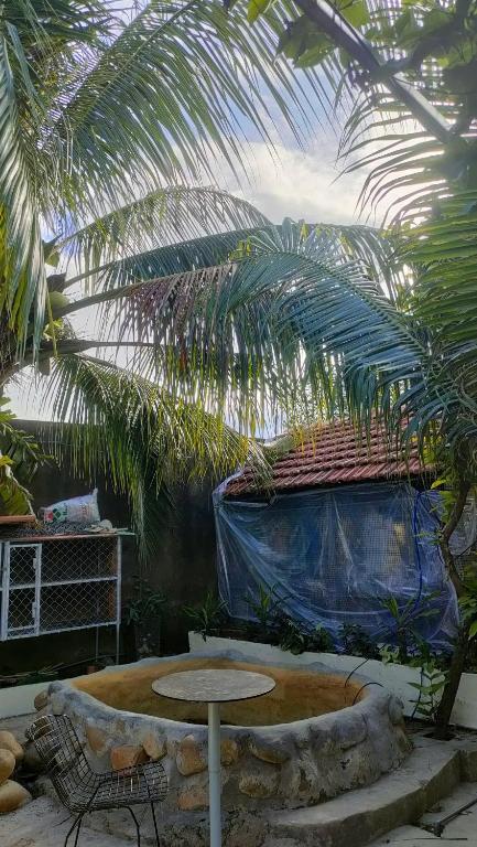 a patio with a table and a palm tree at Happy Farm Homestay in Ấp Long Ðại