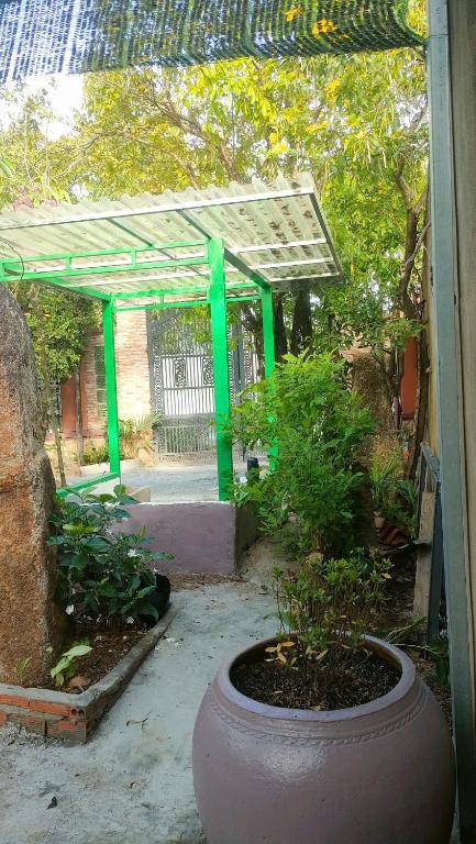 a garden with a large pot and a green pergola at Happy Farm Homestay in Ấp Long Ðại