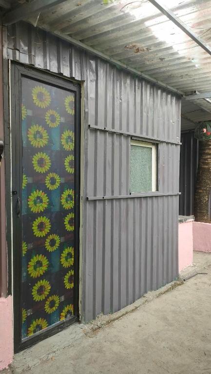 a metal building with a door with flowers on it at Happy Farm Homestay in Ấp Long Ðại