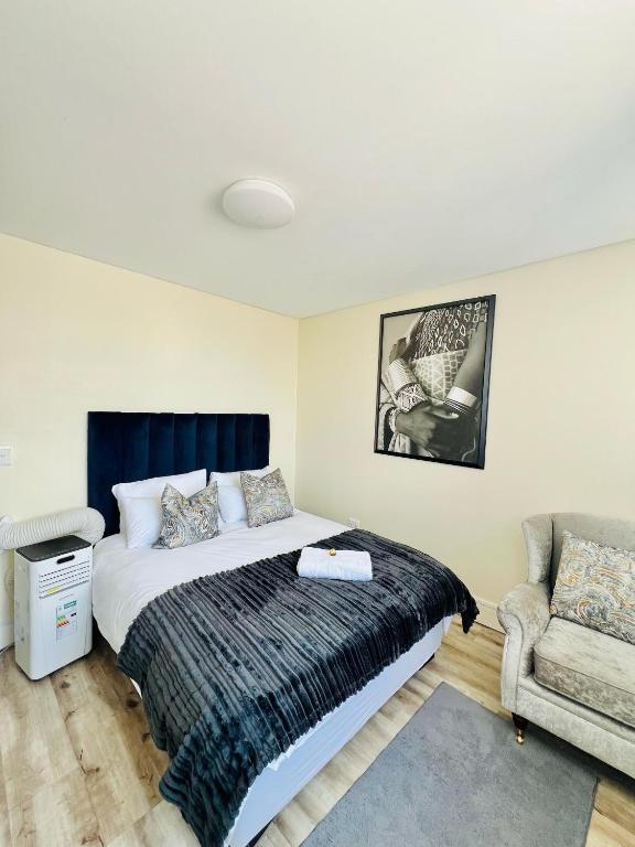 a bedroom with a bed and a chair at C&J Luxe Apartments in Windhoek