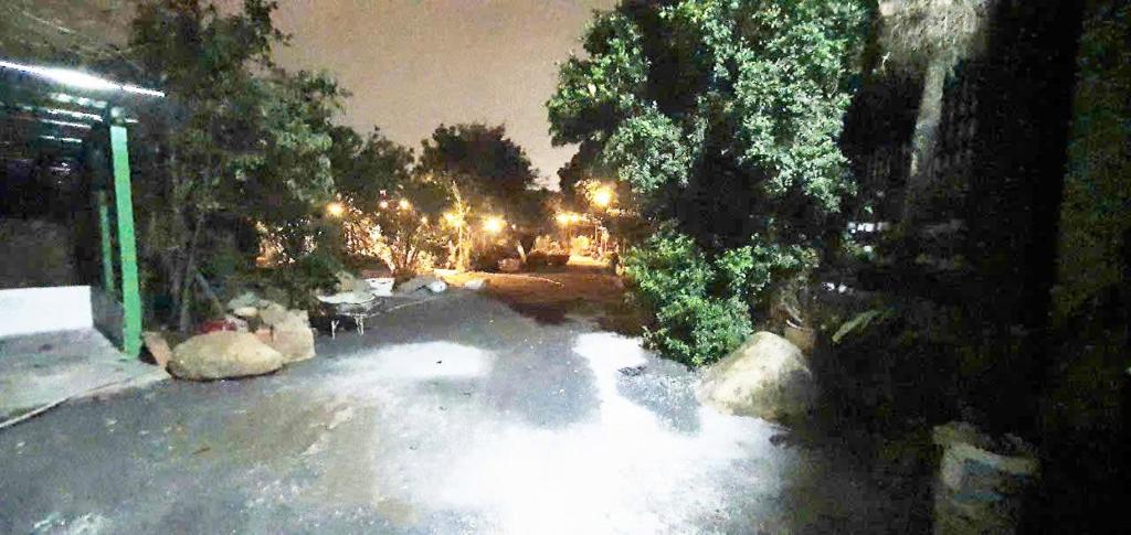 an empty parking lot at night with trees and lights at Happy Farm Homestay in Ấp Long Ðại