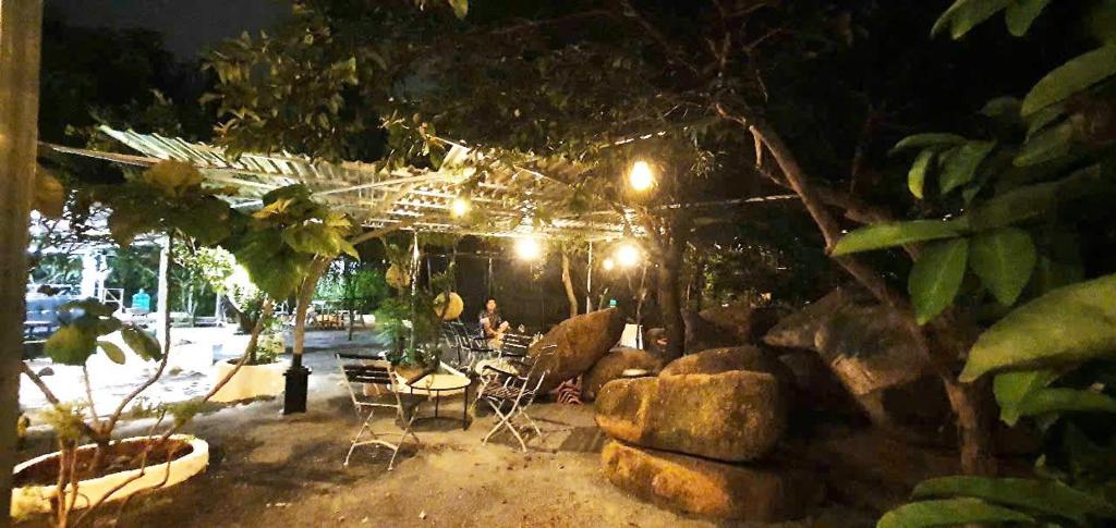 a patio with a table and chairs at night at Happy Farm Homestay in Ấp Long Ðại