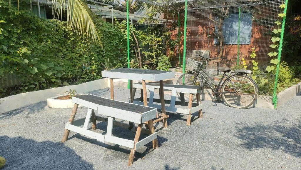 two picnic tables and a bike next to a building at Happy Farm Homestay in Ấp Long Ðại
