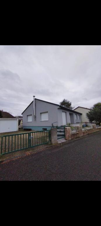 une maison blanche avec une clôture à côté d'une rue dans l'établissement Maison Chaleureuse, à Illkirch-Graffenstaden