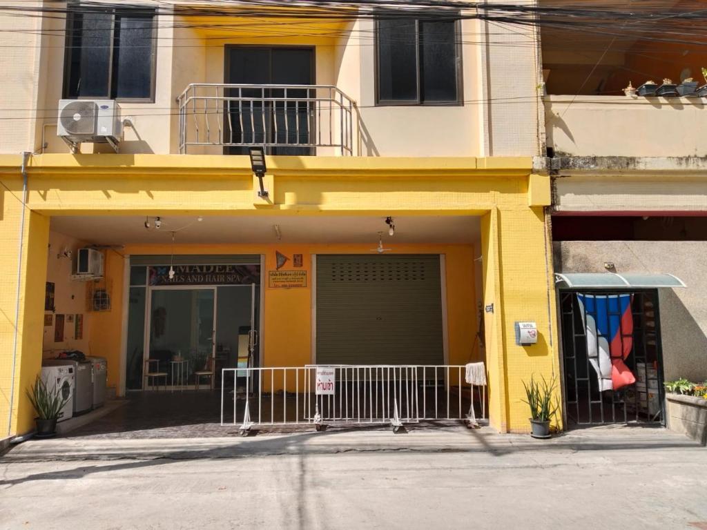 a yellow building with a garage in front of it at Maijom Apartments in Jomtien Beach