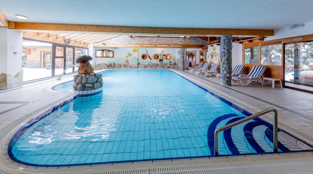 una piscina en una habitación de hotel con piscina en Hôtel L'Ensoleillé, en La Chapelle-dʼAbondance