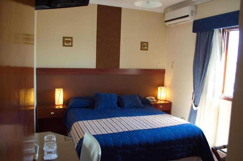 a bedroom with a blue bed and a window at Duplex Centro Salta in Salta