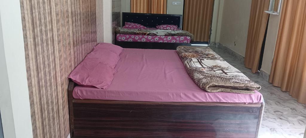 a small bed in a room with purple sheets at Shri Raameshvaram vidya vila in Ayodhya