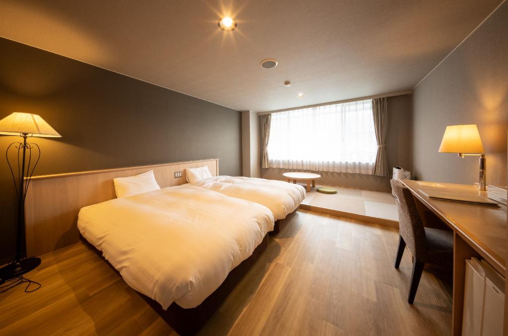 Postel nebo postele na pokoji v ubytování Nakatsugawa Onsen Hotel Hanasarasa