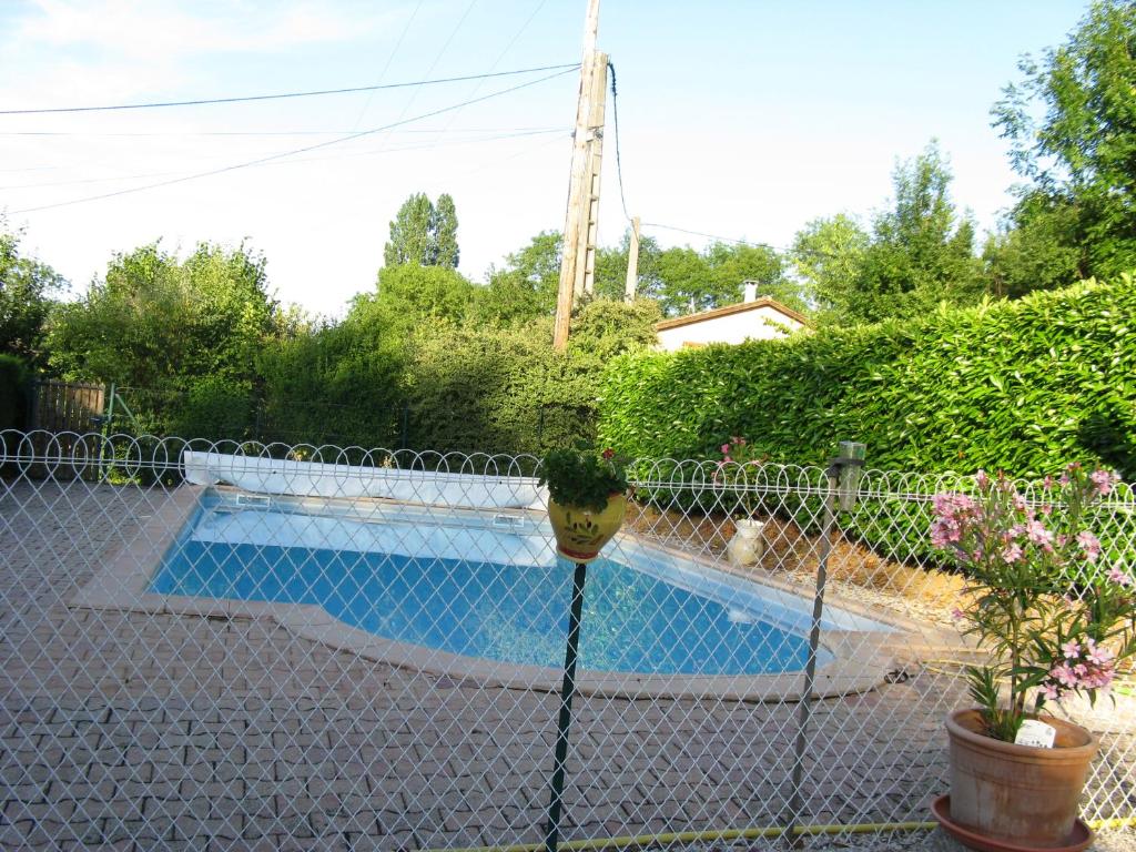 une clôture avec une piscine dans la cour dans l'établissement Le Marverand, à Saint-Julien
