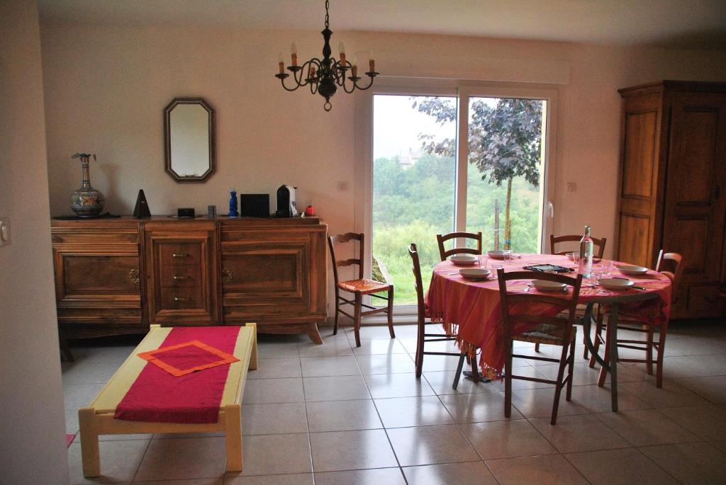 comedor con mesa, sillas y ventana en Gite De La Suche, en Lamastre