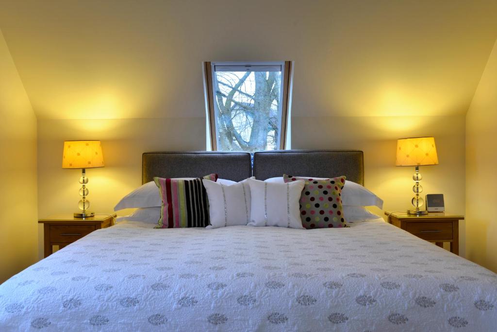 a bedroom with a large bed with two lamps at Brae House in Aberfeldy
