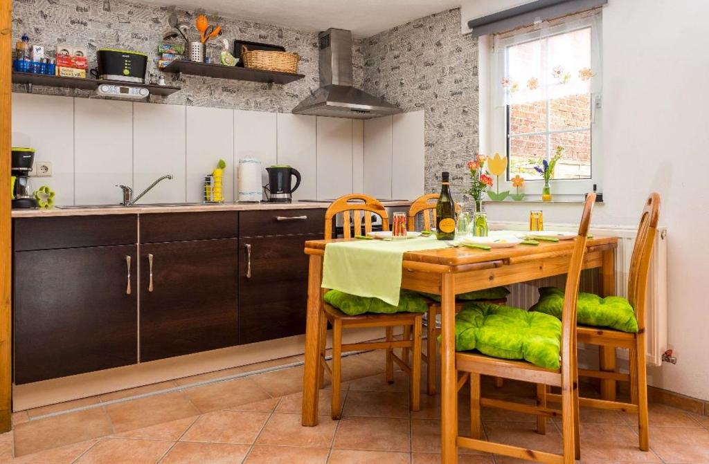 - une cuisine avec une table en bois, des chaises et un évier dans l'établissement Stilvolles Ferienhaus in der Altstadt, à Röbel