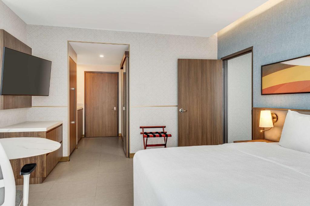 a hotel room with a white bed and a desk at Hilton Garden Inn San Jose Airport City Mall in Alajuela City
