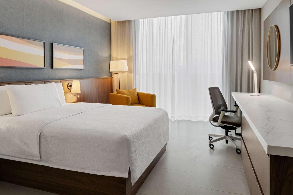 a hotel room with a bed and a desk at Hilton Garden Inn San Jose Airport City Mall in Alajuela City