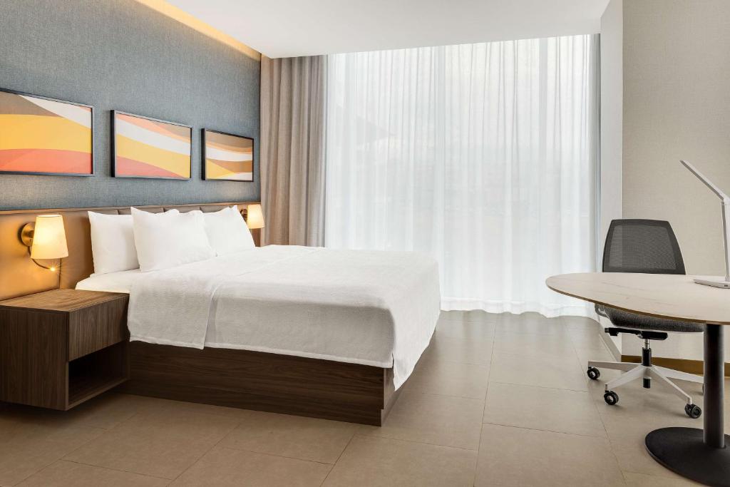 a hotel room with a bed and a desk at Hilton Garden Inn San Jose Airport City Mall in Alajuela City