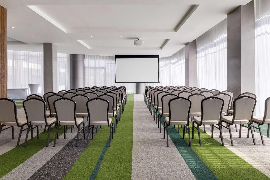 a conference room with chairs and a projection screen at Hilton Garden Inn San Jose Airport City Mall in Alajuela City