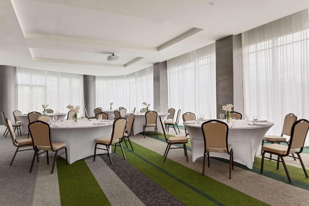 a conference room with white tables and chairs at Hilton Garden Inn San Jose Airport City Mall in Alajuela City
