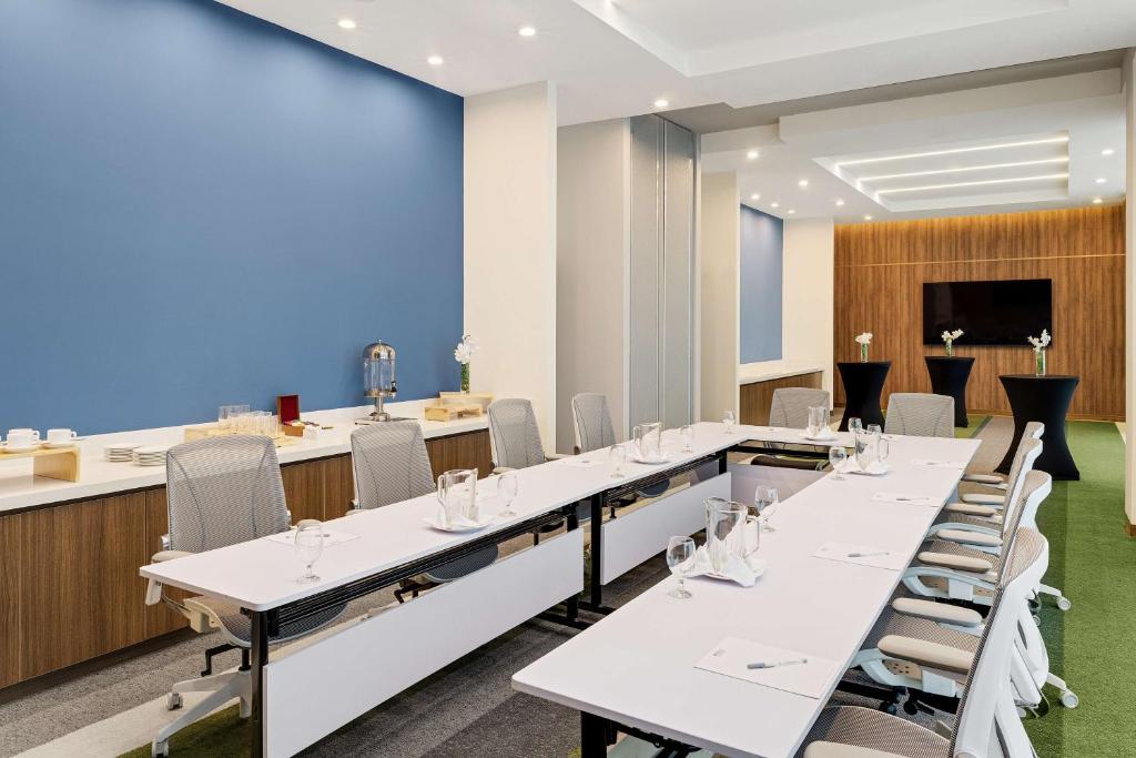 a conference room with white tables and chairs at Hilton Garden Inn San Jose Airport City Mall in Alajuela City