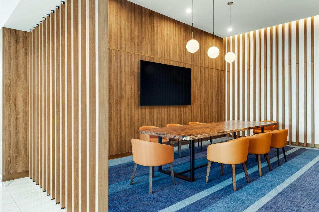 a conference room with a wooden wall with a table and chairs at Hilton Garden Inn San Jose Airport City Mall in Alajuela City