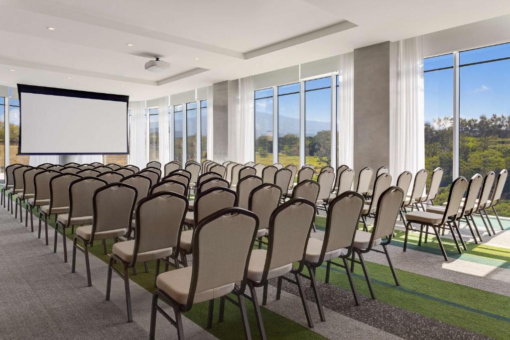 a row of chairs in a room with a projection screen at Hilton Garden Inn San Jose Airport City Mall in Alajuela City
