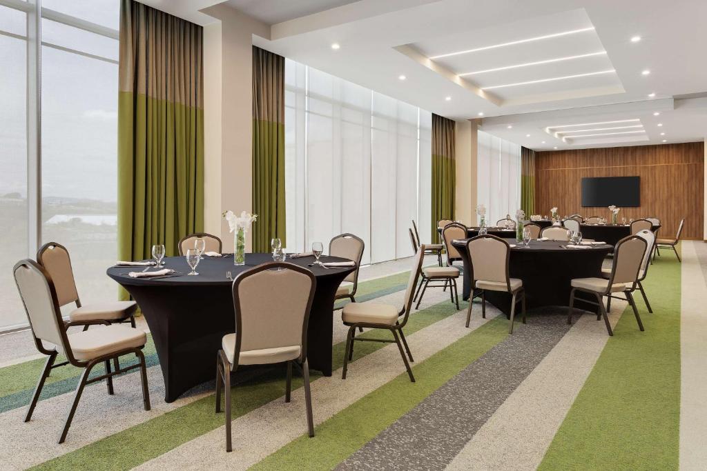 a conference room with tables and chairs and a tv at Hilton Garden Inn San Jose Airport City Mall in Alajuela City