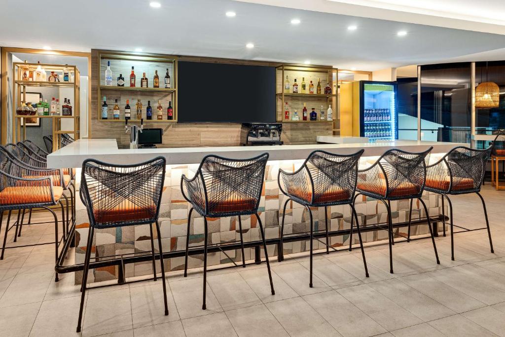 a bar in a restaurant with chairs around it at Hilton Garden Inn San Jose Airport City Mall in Alajuela City