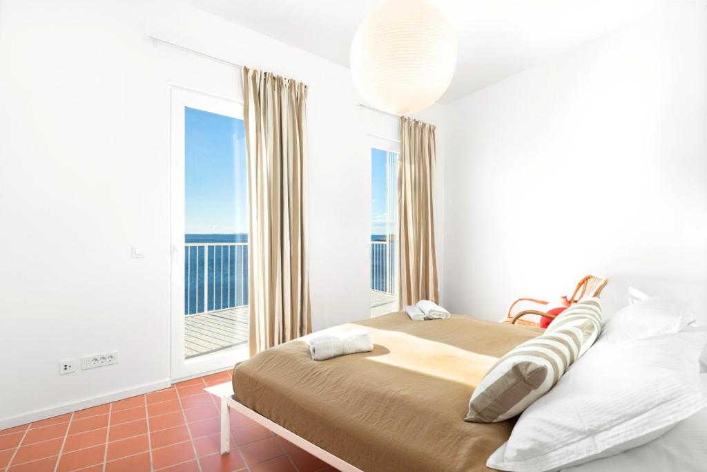a bedroom with a bed and a large window at Milnamour, Whole House by the Sea with Parking in Hvar