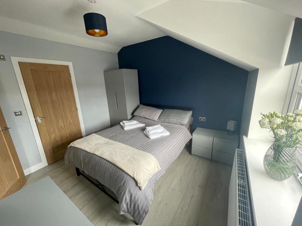 a bedroom with a bed with a blue wall at Newton house in Burton Fleming