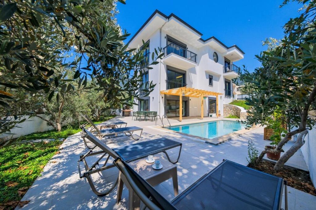 una vista esterna di una villa con piscina di Arıcı evi delux luxury villa with indoor and outdoor pool a Fethiye