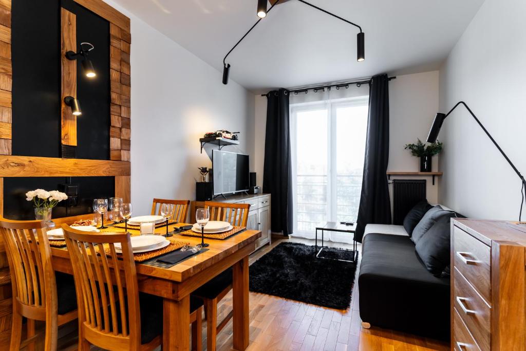 ein Wohnzimmer mit Tisch und Couch in der Unterkunft MAESTRIA POLANICA in Polanica-Zdrój