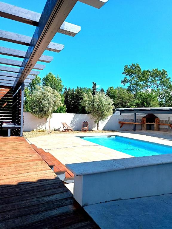 - une piscine dans un jardin avec une terrasse en bois dans l'établissement Villa Moderne avec Piscine proche Narbonne, à Sallèles-dʼAude