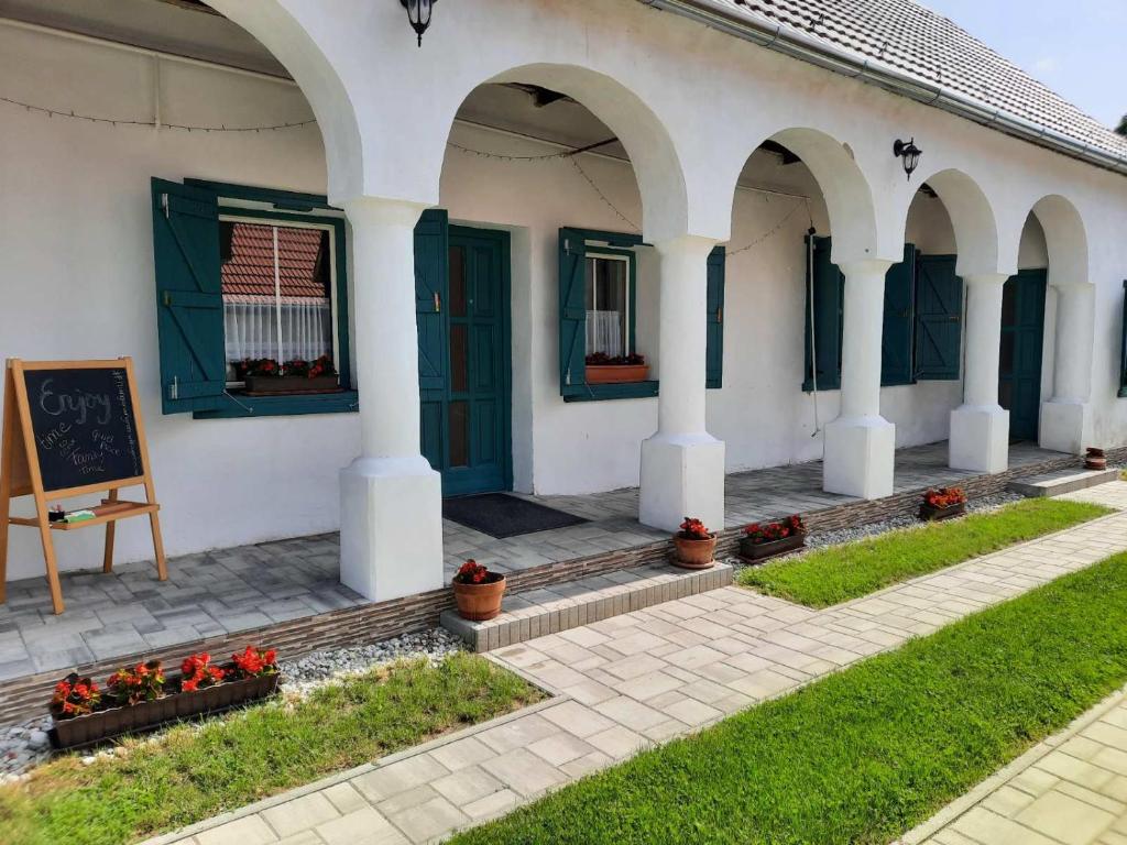 a building with arches and a chalkboard and some flowers at Green Village House in Ganna