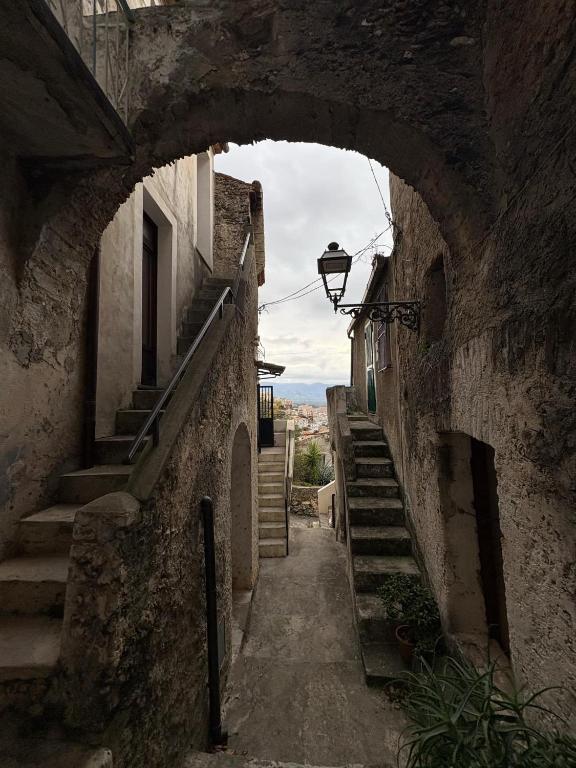 an alley with an arch in a stone building with stairs at Casa Nico and Vico in Scalea