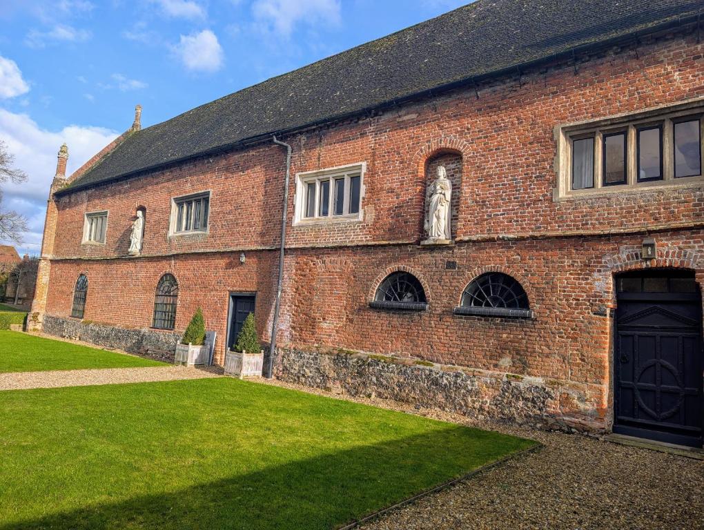 a red brick building with statues on the side at Five Star Luxury - Oxnead Hall in Burgh next Aylsham