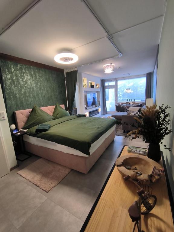 a bedroom with a large bed and a living room at Harz High End Fewo Nicholas 4 Sterne DTV in Goslar