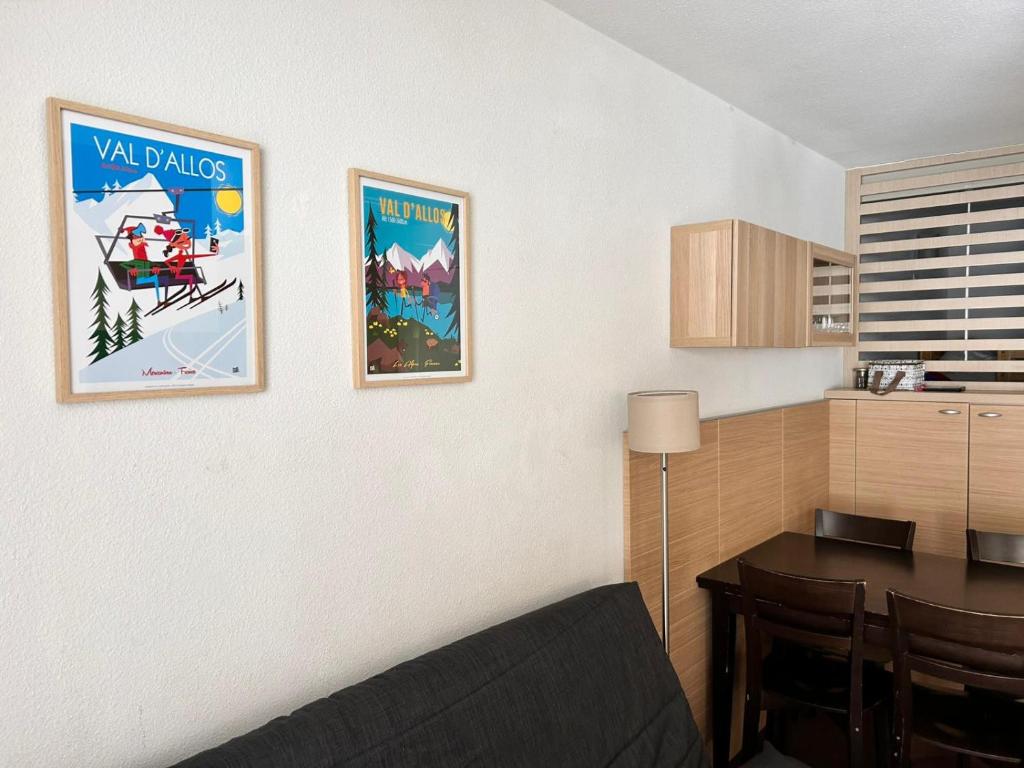une cuisine avec deux affiches sur le mur et une table dans l'établissement Chalets du Verdon 3302 - pied des pistes -6 pers, à La Foux