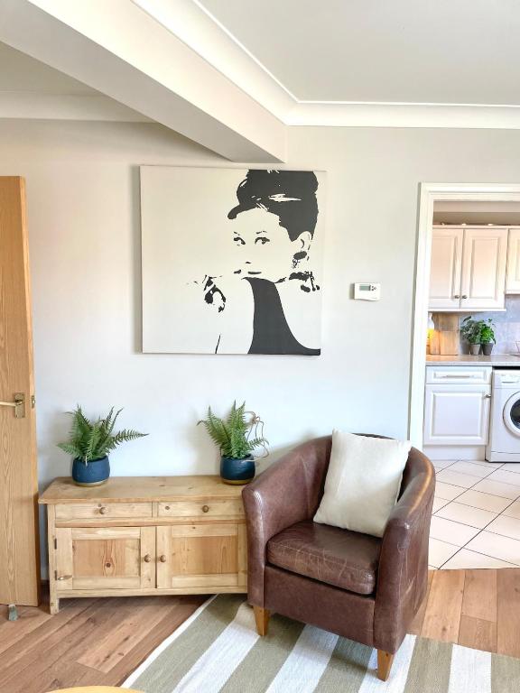 a living room with a chair and a picture on the wall at Signal Rest in Swindon