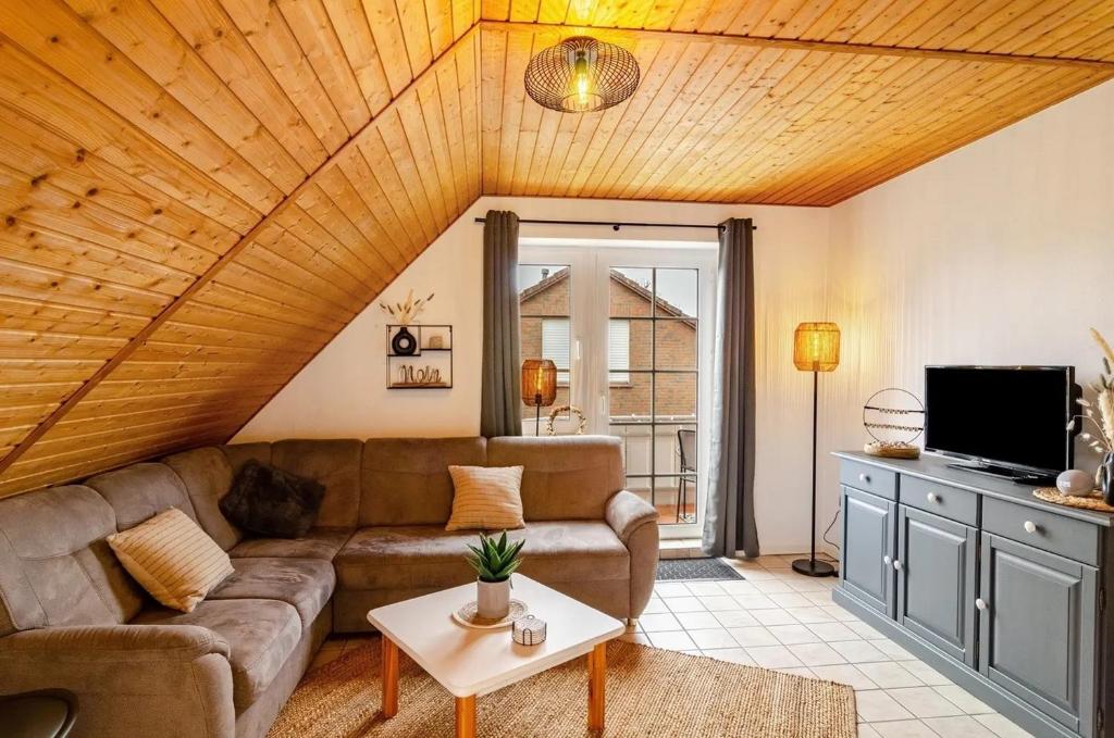 un soggiorno con un divano e una TV di KleineMuschelbude a Dornum