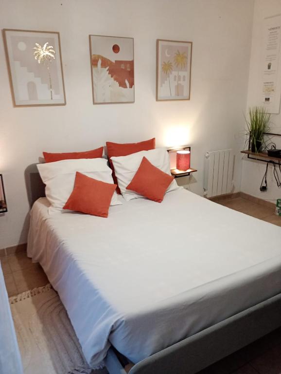 - un grand lit blanc avec des oreillers rouges dans l'établissement B010 Appartement Disneyland Paris France, à Montévrain