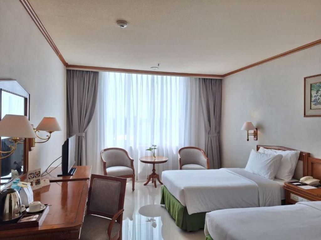 Postel nebo postele na pokoji v ubytování Hotel Sahid Jaya Solo