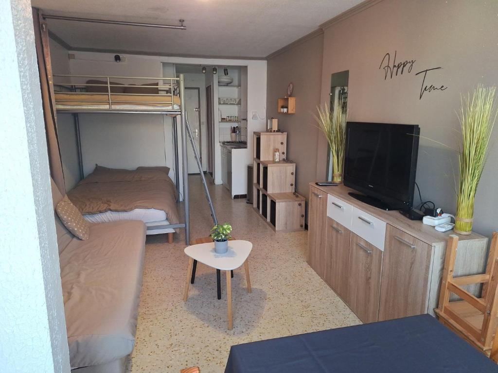Cette petite chambre comprend des lits superposés et une télévision. dans l'établissement Appartement studio-cabine 6 Couchages Cap-D'Agde, au Cap d'Agde