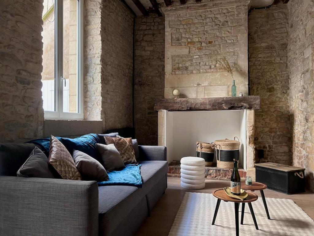 un salon avec un canapé et une cheminée dans l'établissement La Maison d'Alcyone by Melrose, à Bayeux