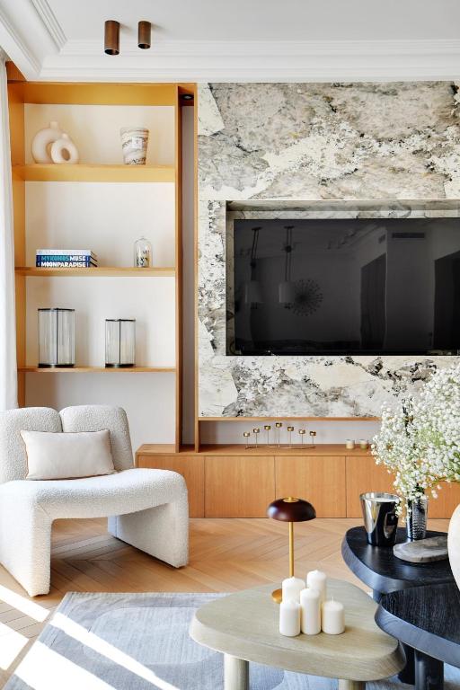 un salon avec une télévision, un canapé et une table dans l'établissement Écrin de Prestige à Dauphine, à Paris