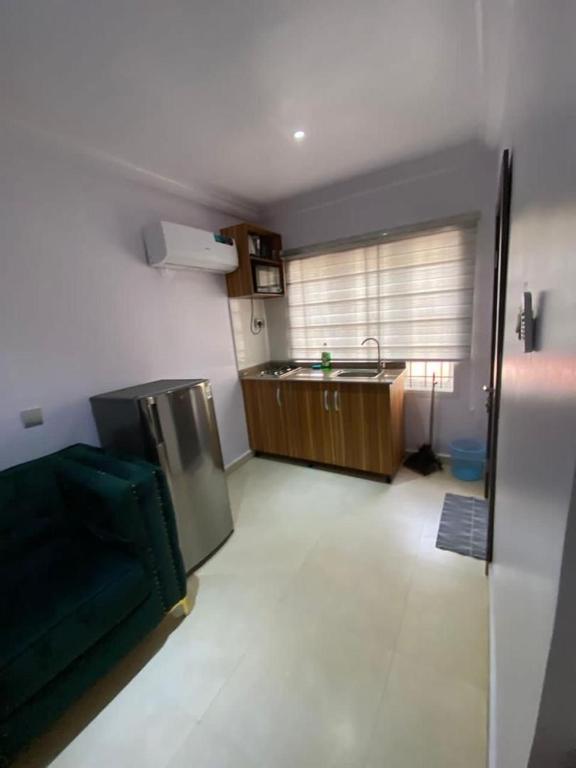 una cucina con un lavandino e un divano in una stanza di Studio apartment a Ikeja