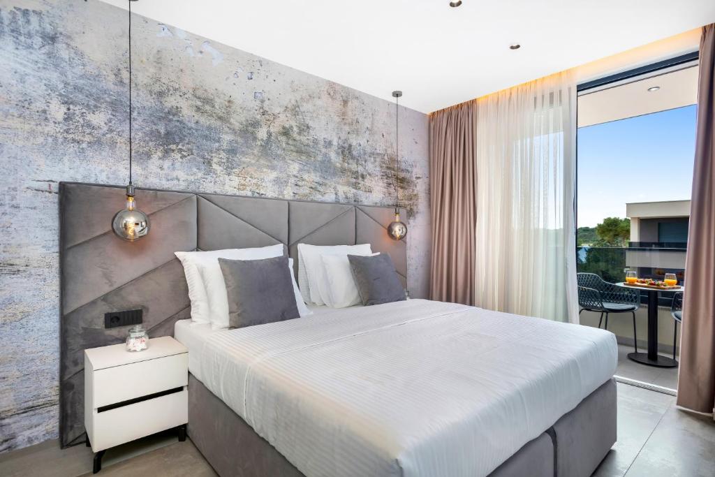 a bedroom with a large bed with a concrete wall at Fly Room - S6 - MPolo in Medulin